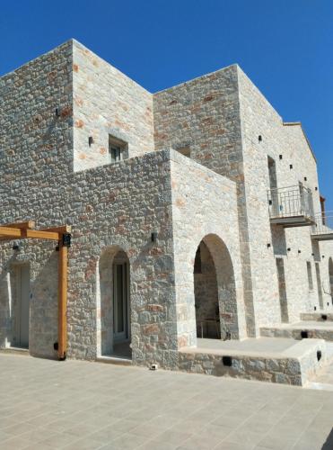 a brick building with a bench in front of it at Terra Di Pietra Exclusive Suites & Apartments in Areopolis