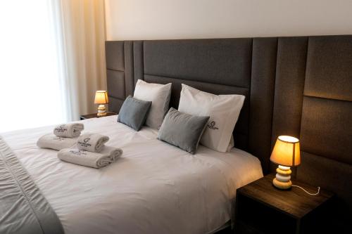 a bedroom with a bed with two towels on it at Guest House Fojo dos Lobos in Fafião