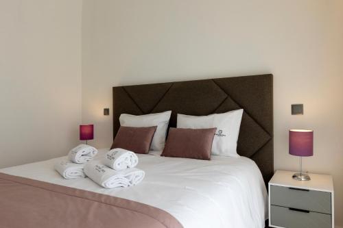 a bedroom with a large white bed with towels on it at Guest House Fojo dos Lobos in Fafião