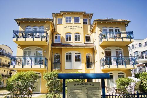a yellow building with balconies and a sign in front of it at strandnah, gratis Nutzung vom AHOI Erlebnisbad und Sauna in Sellin - Kurparkresidenz FeWo10 in Baabe