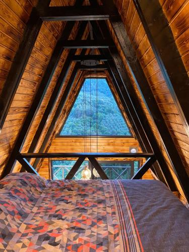 Bett in einem Zimmer mit einem großen Fenster in der Unterkunft Bungalow In Iznik in İznik