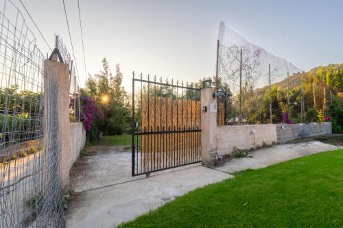 a metal gate in a yard with a grass field at To Ktimataki in Agios Gordios