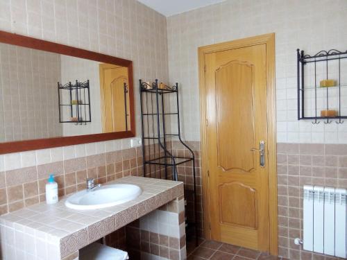 ein Bad mit einem Waschbecken und einem Spiegel in der Unterkunft La Casa de Marta in Chiloeches
