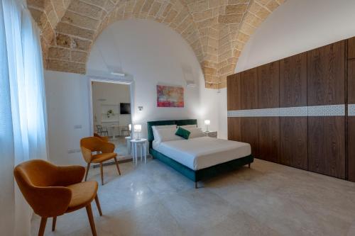 - une chambre avec un lit et deux chaises dans l'établissement The Secret Door 10, à Cellino San Marco