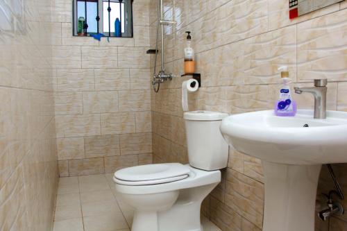 a bathroom with a toilet and a sink at Rare APT for solo and couple Travellers in Kampala