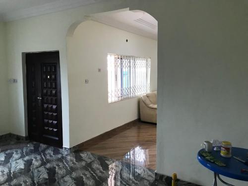 een woonkamer met een tafel en een deur met wijnflessen bij Buzu Apartments in Tamale