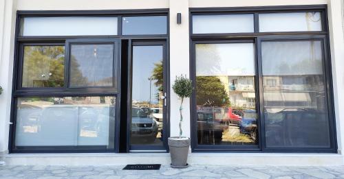 a store front with black windows and a potted plant in front at Avramiou Loft Studio in Agios Rokkos