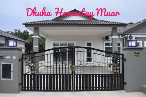 a house with a black gate in front of it at Dhuha Homestay Muar in Muar