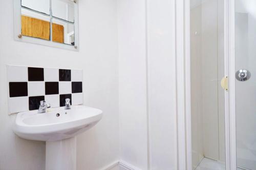 een witte badkamer met een wastafel en een douche bij Bru Bar & Hostel in Cork