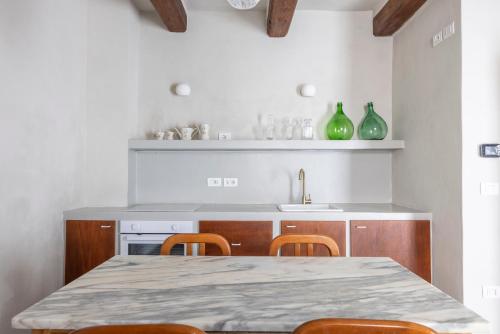 a kitchen with a table and some green vases at Donna Rina - suggestiva casa nel centro storico in Colledimezzo