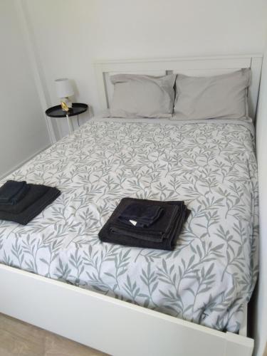 a bed with two towels and a tray on it at Casa Guti in Costa da Caparica