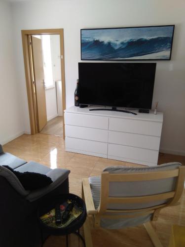 a living room with a flat screen tv on a white dresser at Casa Guti in Costa da Caparica