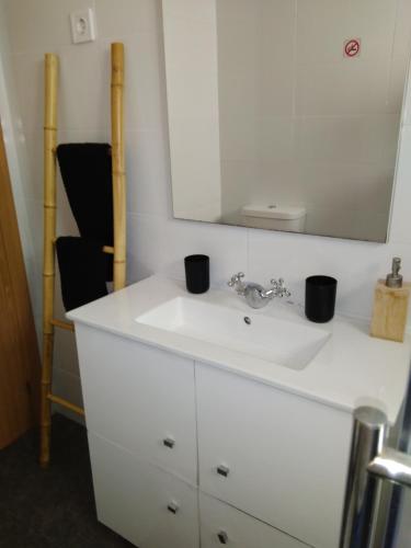 a bathroom with a white sink and a mirror at Casa Guti in Costa da Caparica