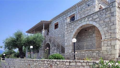 un edificio de piedra con una escalera delante en Olive Stonehouses - Alkistis en Kalamata