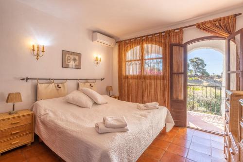 a bedroom with a bed and a large window at Fuente Del Baden in Nerja