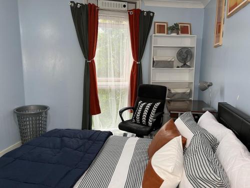 a bedroom with a bed and a chair and a window at Quayside Deluxe Double Room in Colchester