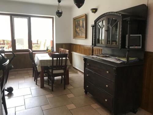 a dining room with a table and a wooden dresser at Pensiunea Iona in Baia Mare