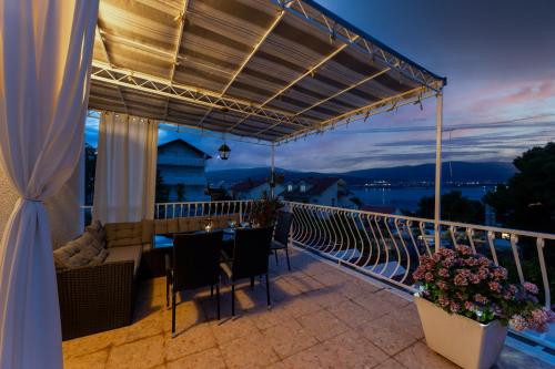 a patio with a table and chairs on a balcony at Treno, Luxurious Apartment with Jacuzzi and Sea-View in Trogir