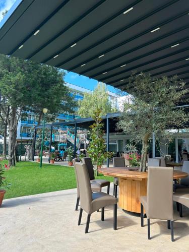 a patio with a table and chairs and a building at Hotel Agora in Neptun