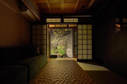 a room with a window with a tree outside at YADORU KYOTO HANARE Tsukikage No Yado in Kyoto