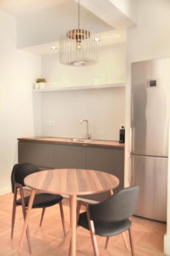uma cozinha com uma mesa e cadeiras e um frigorífico em Citybreak Apartments 301 em Atenas