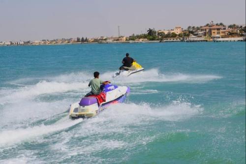 two people riding on a boat in the water at Fanara Apartments Armed Forces in Fayed