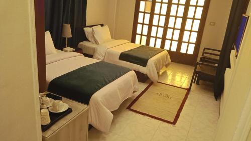 a hotel room with two beds and a mirror at Fanara Apartments Armed Forces in Fayed