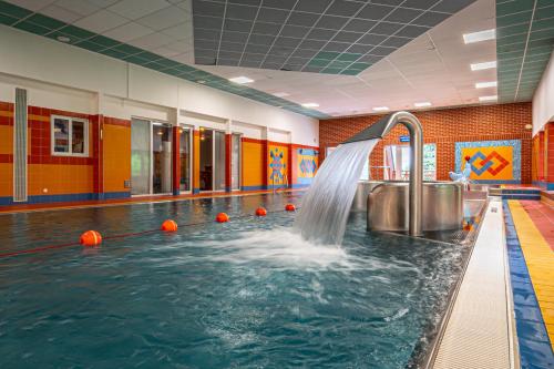 a swimming pool with a water fountain in a gym at Hotel Sepetná in Ostravice