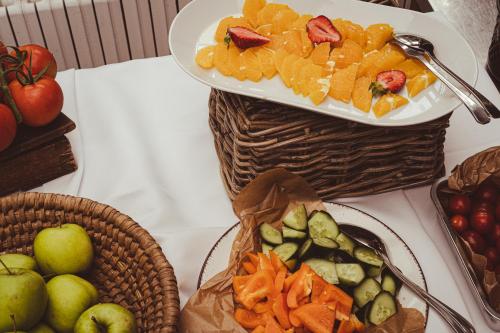 a table with two plates of fruit and baskets of fruit at Hotel Sepetná in Ostravice