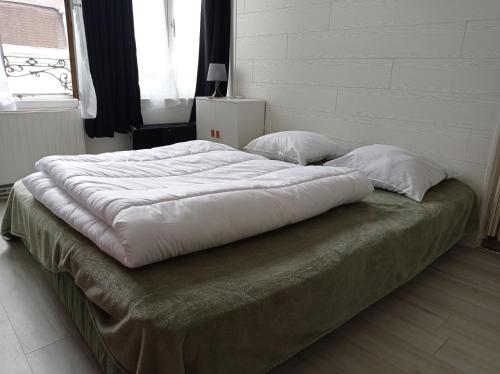 Una cama grande con dos almohadas encima. en L'Opale 3, studio 2 pers, en Berck-sur-Mer