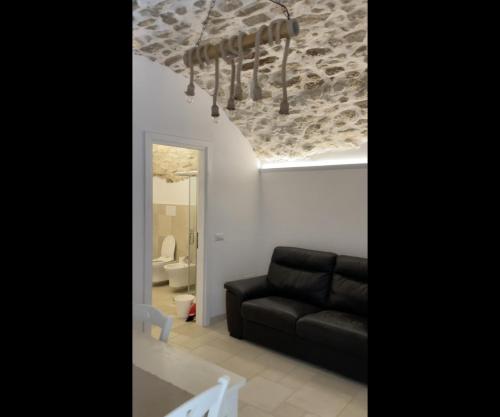 a living room with a black couch and a ceiling at Arcaroli Borgo Vico "Luxe" in Vico del Gargano