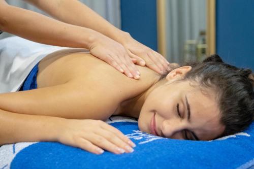 a woman getting a massage from a therapist at Gran Hotel Las Fuentes in Alcossebre