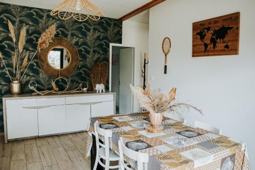 une salle à manger avec une table et un miroir dans l'établissement La Villa Ô Bois - Billard & Baby-Foot - face à la forêt, à Séméac