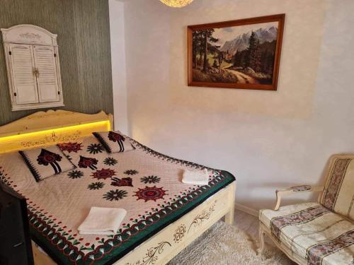 ein kleines Schlafzimmer mit einem Bett und einem Stuhl in der Unterkunft KONWALIA in Zakopane