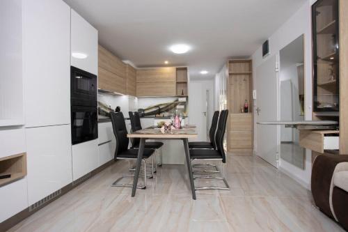 cocina y comedor con mesa y sillas en Апартамент за гости Ивви-1, en Burgas