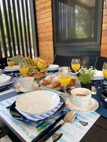 a table with plates of food and glasses of orange juice at INNOVA TravelVir Mobhome Eli in Sveti Petar