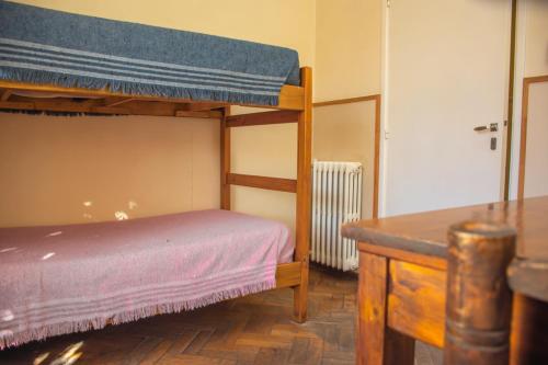 a bedroom with a bunk bed and a desk at Alamo Hostel & Suites in Mendoza