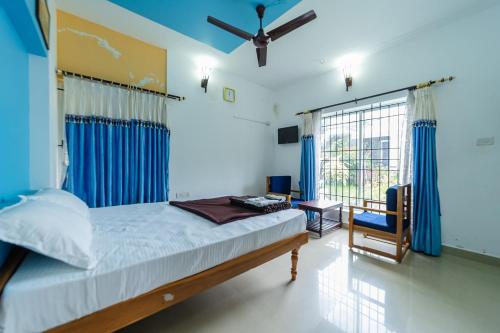 a bedroom with a bed and a blue wall at KBS Sree Paradise Kodai in Kodaikānāl