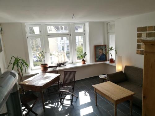 uma sala de estar com um sofá, uma mesa e cadeiras em Stadtvilla em Kiel