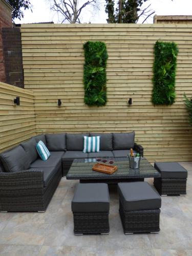 eine Terrasse mit einem Sofa, einem Tisch und Stühlen in der Unterkunft Historic City Centre Town House in Chester