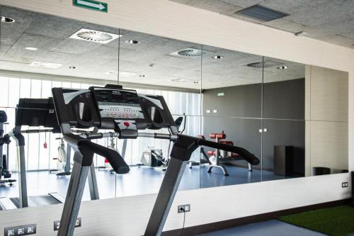 a gym with a mirror and a treadmill at AZZ Pamplona Norte Hotel in Pamplona