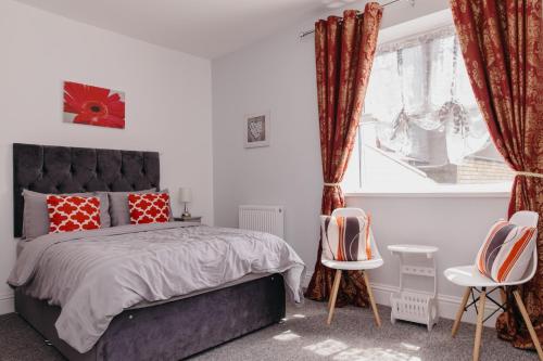 a bedroom with a bed and two chairs and a window at Sherwood Hotel in Margate