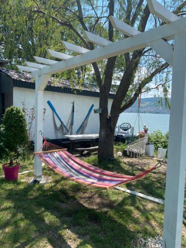 a hammock under a pergola next to a lake at CHALET Orsova in Orşova