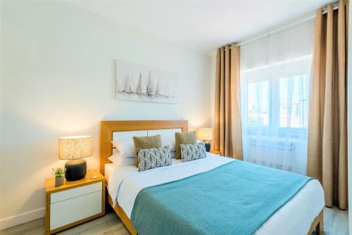 um quarto com uma cama grande e uma janela em Bela Vista B em Lisboa