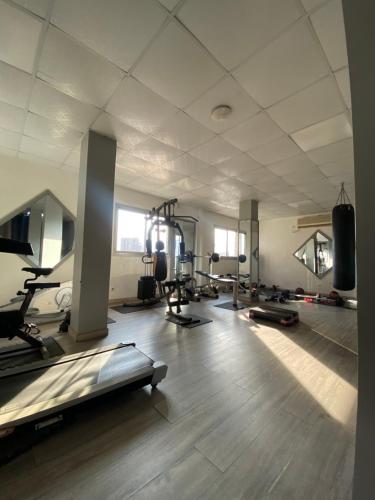 a gym with several treadmills and machines in a room at Bano Palace Hotel in Douala