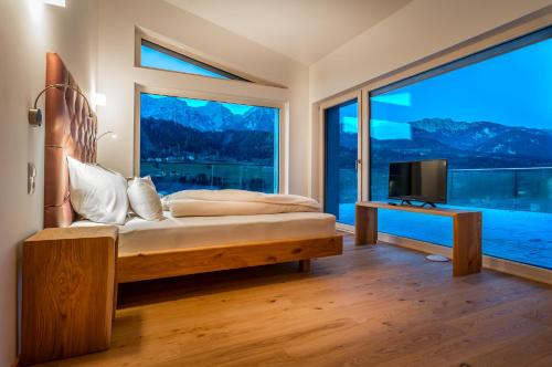 a bedroom with a bed and a large window at Chalets Coburg in Schladming