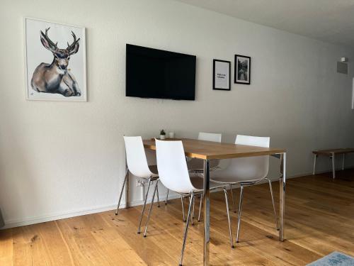 ein Esszimmer mit einem Tisch und einem Hirsch an der Wand in der Unterkunft Ferienwohnung 405 Haus Allod in Lenzerheide