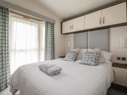 a bedroom with a large white bed with blue curtains at No 4 Fistral in Newquay