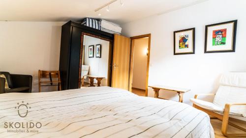 a bedroom with a large white bed and a chair at Haus Cotton 4.5 Room Apartment in Breiten