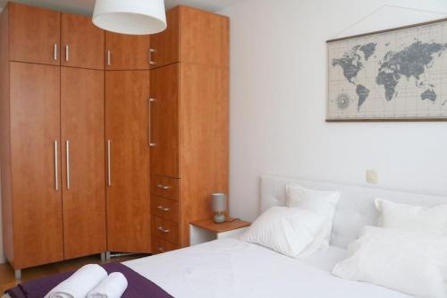 Schlafzimmer mit einem weißen Bett und einem Holzschrank in der Unterkunft Azure Horizon in Dubrovnik